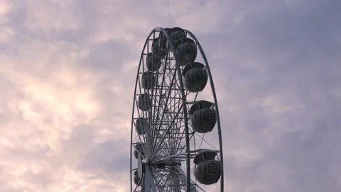 Rotating nostalgic Ferris Wheel - sunset cloudy sky - real time Stock Footage 140641131