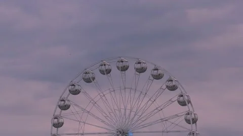 Rotating nostalgic Ferris Wheel - sunset cloudy sky - real time Stock Footage 140713766