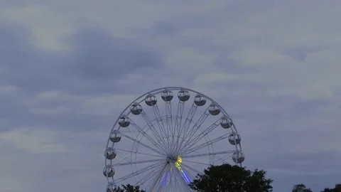 Rotating nostalgic Ferris Wheel - sunset cloudy sky - real time Stock Footage 140727261