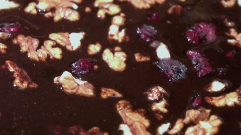 Rotating nuts and cranberry in chocolate in 4K Stock Footage 93972080