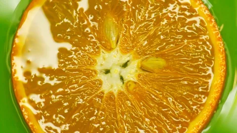 Rotating orange with green background. Beautiful light in the water Stock Footage 125885207