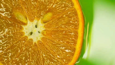 Rotating orange with green background. Beautiful light in the water Stock Footage 125885307