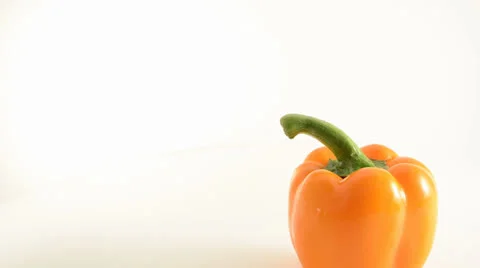 Rotating Orange Pepper On Acrylic Against White - Crane Down Video stock 23845985