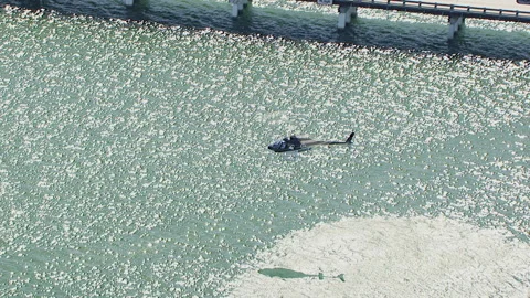 Rotating over lone chopper hovering close to water Stock Footage 136200960
