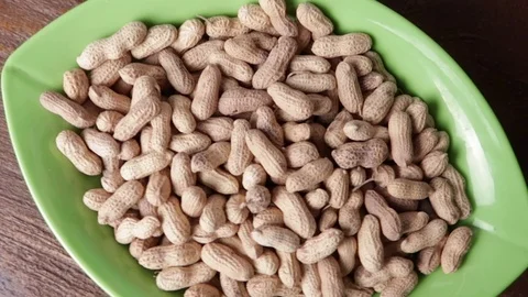 Rotating peanuts in a green bowl Stock Footage 121702281