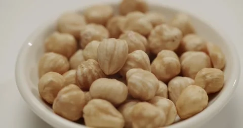 Rotating peeled hazelnuts in a white bowl Stock Footage 344316534