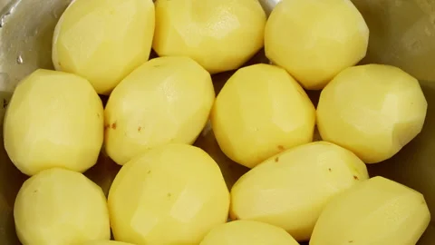 Rotating Peeled Raw Yellow Potatoes in Metal Bowl Stock Footage 344015928