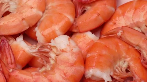 Rotating pile of cooked shrimp in shells with vibrant orange color on clean Stock Footage 310785105