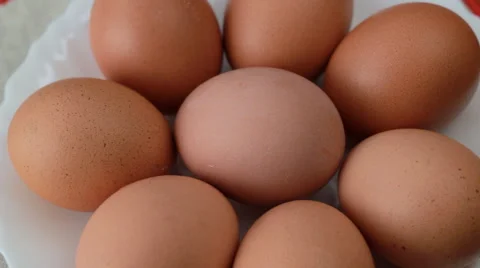 Rotating pile of fresh chicken eggs on a white plate Stock Footage 60921082