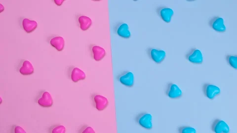 Rotating pink and blue background with heart shaped candies, concept of a gende Stock Footage 198568806