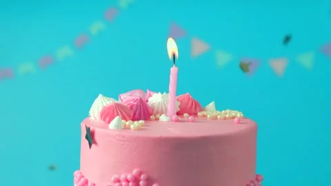 Rotating pink cake with a burning candle concept birthday parties or anniversary Stock Footage 248344959