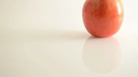 Rotating Pink Lady Apple On Acrylic Against White - Crane Up Stock Footage 24470169