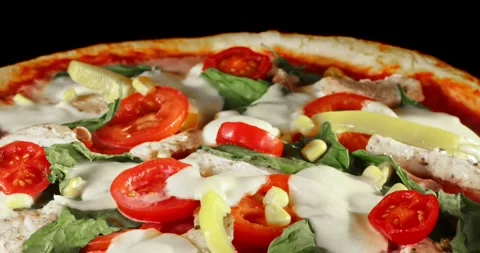 Rotating pizza during the baking process, isolated on a black background. Stock Footage 328469008