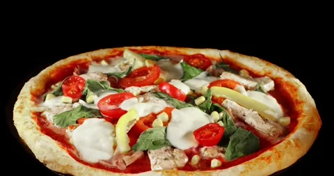 Rotating pizza during the baking process, isolated on a black background. Stock Footage 328469018