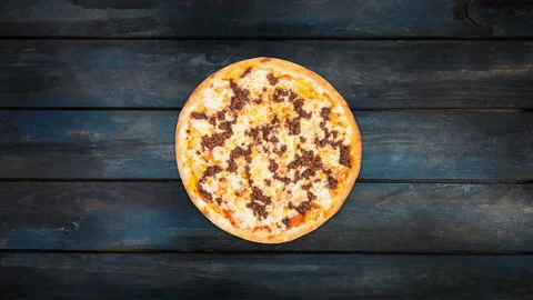 Rotating pizza with minced meat on a dark wooden background. Top view center Stock Footage 88506654