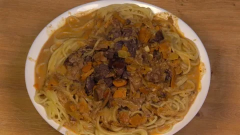 Rotating plate with spaghetti and chicken gizzards liver and vegetables Stock Footage 345422350
