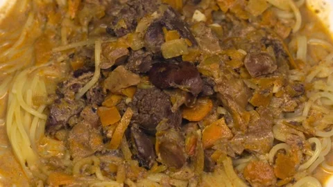 Rotating plate with spaghetti and chicken gizzards liver and vegetables Stock Footage 345422358