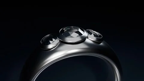 Rotating polished ring after camera movement, revealing three bezel-set stones Stock Footage 339194305