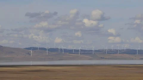 Rotating propellers of windmill turbines on wind farm over Lake george – 4k. Stock Footage 153637099