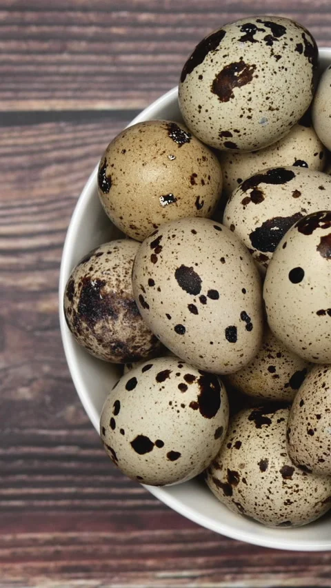 Rotating Quail Eggs On A White Plate On A Wooden Background. Top View. Close Up. Stock Footage 266458895