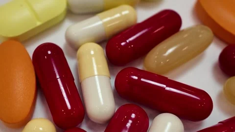 Rotating red and white capsules and pills macro close up Stock Footage 345164399