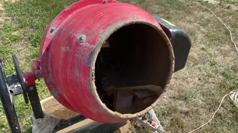 Rotating red cement mixer with clay, water and sand inside Stock Footage 316539389