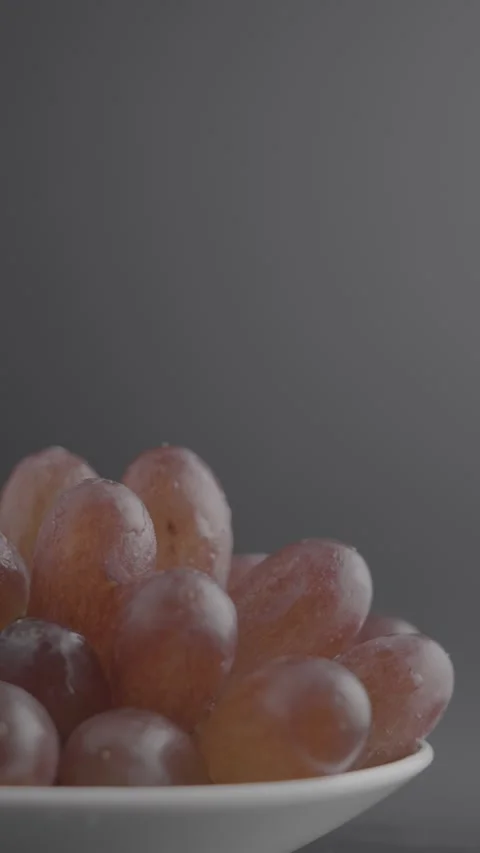 Rotating Red Grapes with Water Drops in White Bowl Stock Footage 344799565