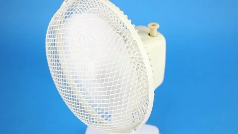 Rotating retro fan on blue background, vintage conditioning,  front upper view Видео 157595037