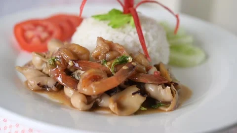 Rotating rice and squid basil with tomatoes and cucumbers on a white plate Stock Footage 160563777