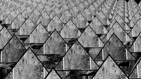 Rotating rows of black and white pyramids with cracked texture. looped moving ba Stock Footage 154031604