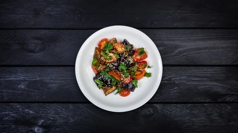 Rotating salad of fried eggplant with tomatoes in Asian dressing. Stock Footage 128601730