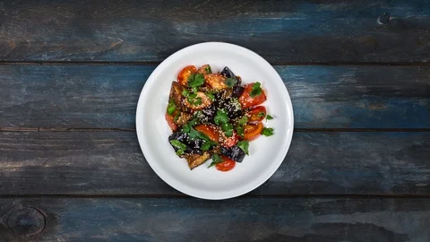 Rotating salad of fried eggplant with tomatoes in Asian dressing. Stock Footage 128601759