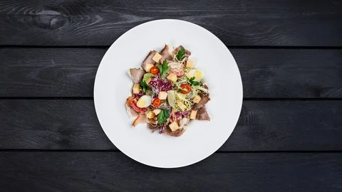Rotating salad on a plate. Mixed lettuce, tomatoes, turkey smoked, smoked duck Stock Footage 129186322