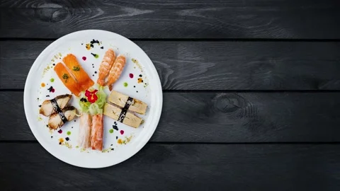 Rotating sashimi set on a white round plate, decorated with small flowers Stock Footage 105607519