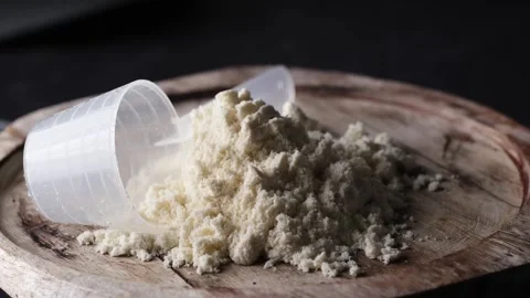 A rotating scoop of whey protein powder on a board. Stock Footage 312461821
