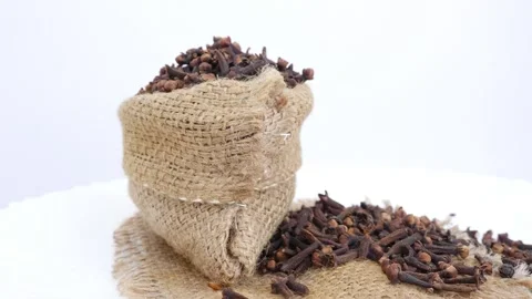 Rotating shot of bag filled with cloves and cloves scattered Stock Footage 147691297
