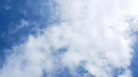 Rotating shot beneath clouds, looking up to blue sky with white fluffy clouds Stock Footage 108194578