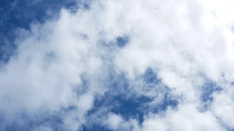 Rotating shot beneath clouds, looking up to blue sky with white fluffy clouds Stock Footage 108194875