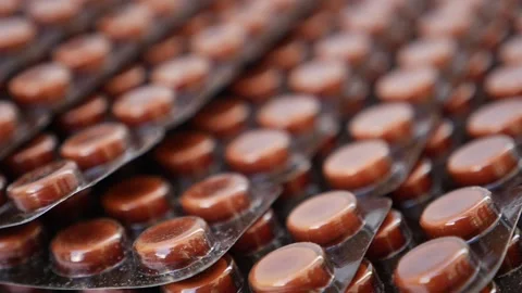 Rotating shot of brown color tablets on a white table Vídeo Stock 147699405