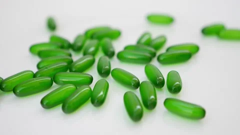 Rotating shot of green capsules on a white table Vídeo Stock 147699639
