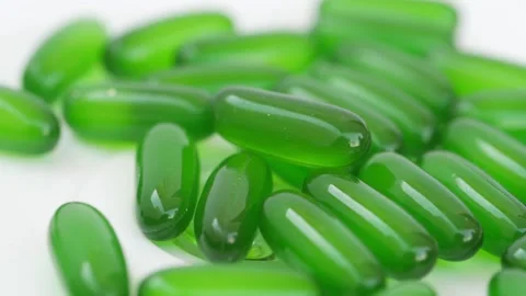 Rotating shot of green tablets, Close shot of green tablets with white backgr 動画素材 147700246
