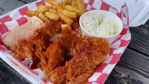 Rotating shot of a Nashville Hot Chicken Tenders, fries, and coleslaw meal. Stock Footage