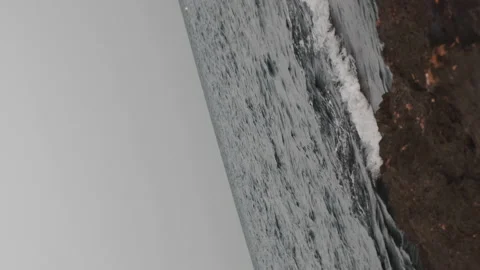 Rotating shot of the sea on a rocky beach Stock Footage 159864341