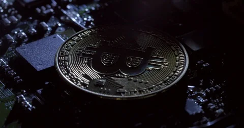 Rotating shot of shadows moving over a casascius bitcoin on a circuit board 動画素材 92525362
