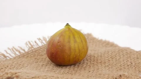 Rotating shot of a single Fig fruit placed over brown bag Stock Footage 148212449