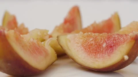 Rotating shot of slices of fig fruit placed over a white table Stock-Footage 148211214