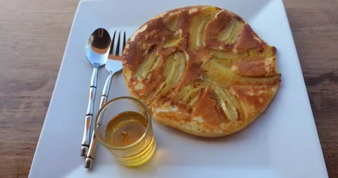 Rotating shot of a white dish with big banana pancake, and honey. Tasty healthy Stock Footage 216023004