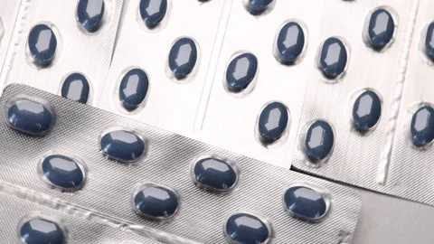 Rotating silver blister pack containing blue pharmaceutical capsules, rotation Stock Footage 279749162