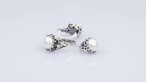 Rotating silver knotted ring and earring with opal with reflection on light g Stock Footage 291171297