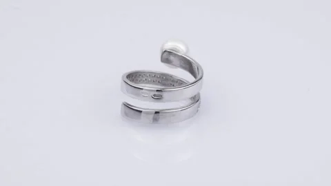Rotating silver ring with reflection on light gray background. Video rotation Stock Footage 291171343